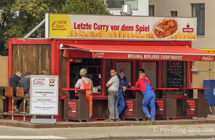 People outside a currywurst kiosk