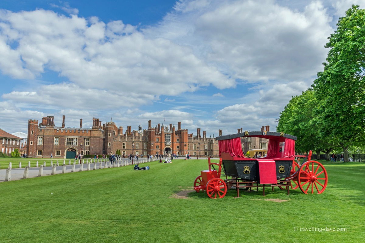 View of a red carriage and Hampton Court Palace