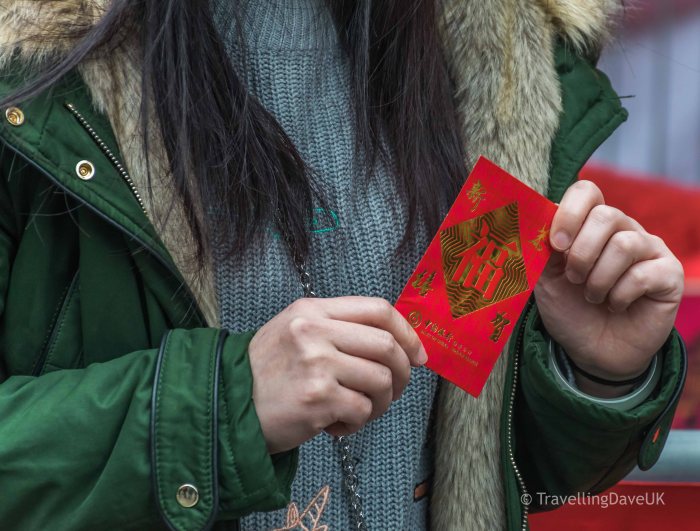 A woman holding a red envelope for Chinese New Year